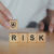 Wooden cubes spelling out risk, representing risk assessment